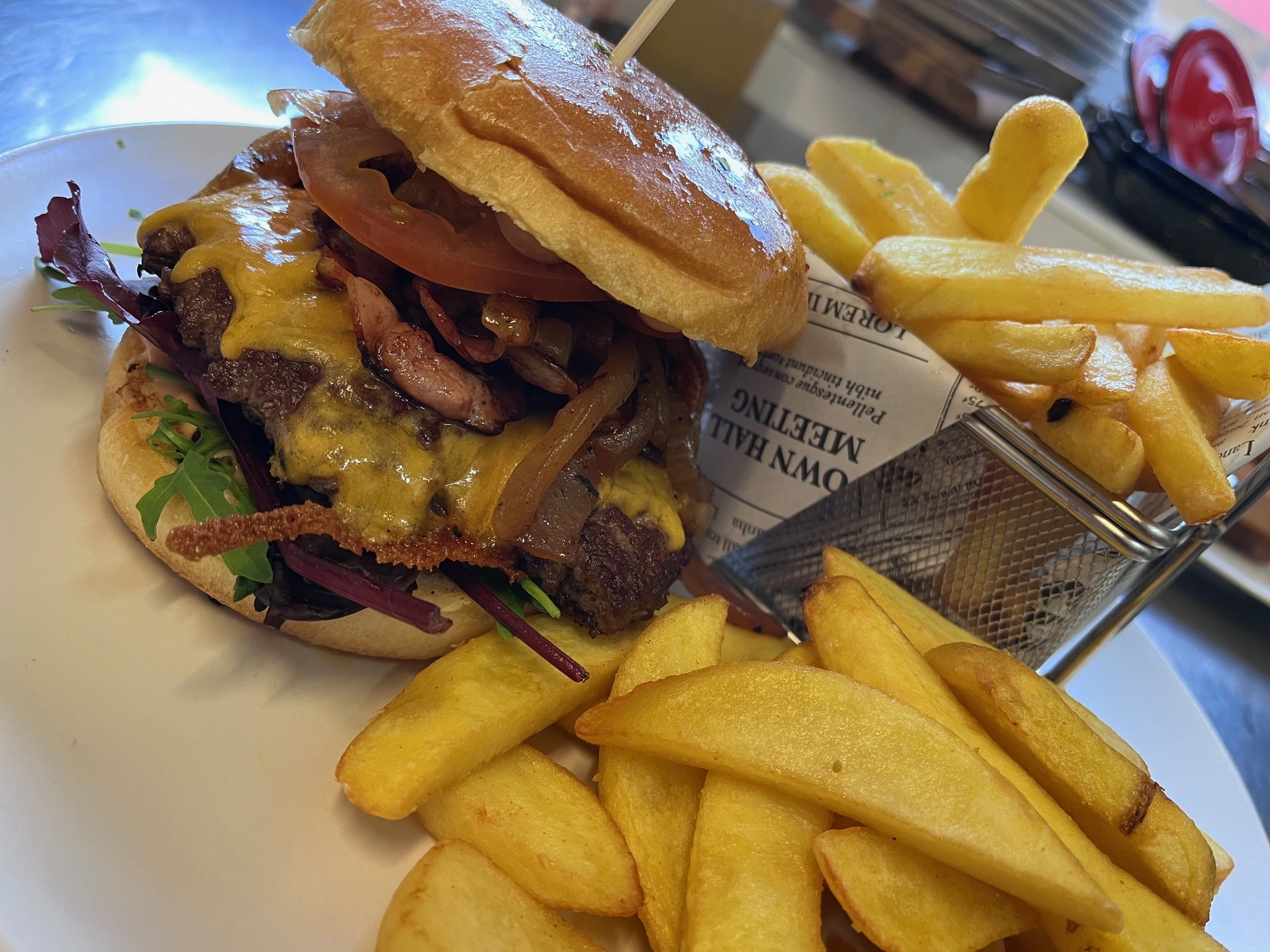 Hausgemachte Burger mit Steak Fries und Cole Slaw Salat (180g 100°% Rindfleisch, Cheddar, Bacon, Tomaten, Zwiebeln, Sauce)